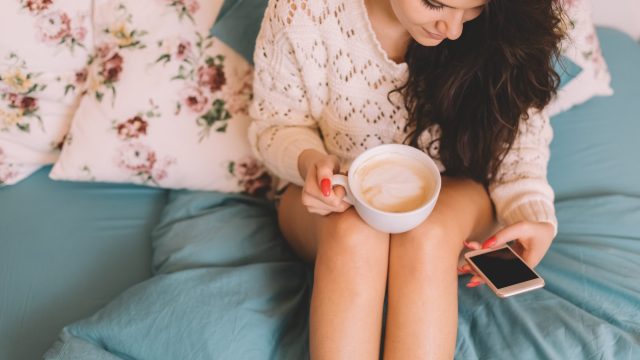 Girl in bed text messaging