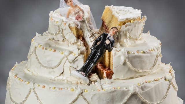 Bride and groom figurines collapsed at ruined wedding cake