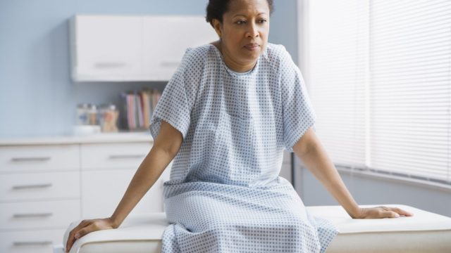 Female patient sitting on examination table in doctor's office