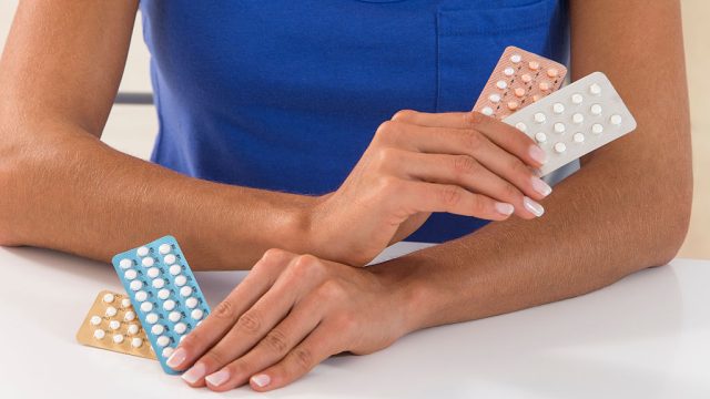 Woman holding birth control pills.