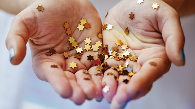 Girl holding gold star confetti