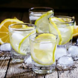 Cold Russian vodka with lemon and ice in shot glass