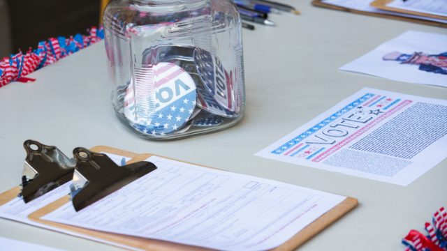 Clipboards and buttons at voter registration table