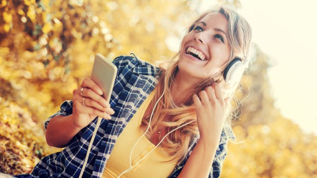Young woman listening to music on smart phone