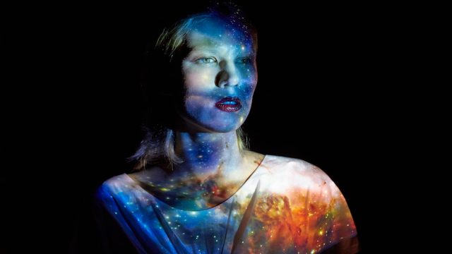 Young Woman with the Universe Projected on to Her
