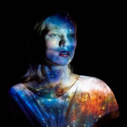 Young Woman with the Universe Projected on to Her