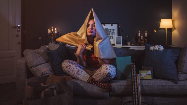 Upset woman at home with christmas gifts