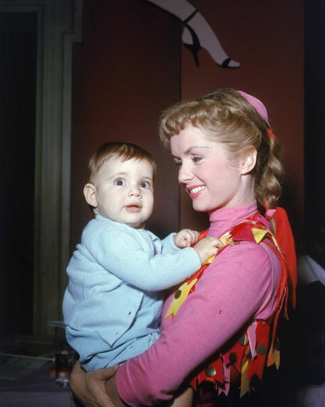 Circa 1956, American actor and singer Debbie Reynolds smiles and holds her infant daughter, Carrie Fisher. (Photo by Jack Albin/Getty Images)