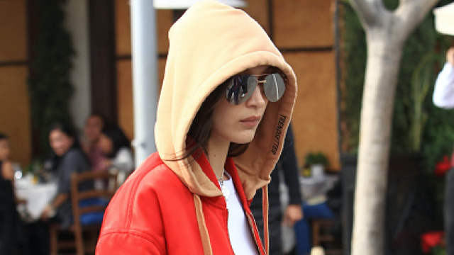 Bella Hadid in Red Tracksuit Carrying a Louis Vuitton Backpack