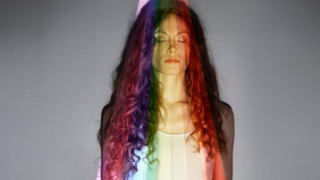 standing in the middle of a rainbow projection