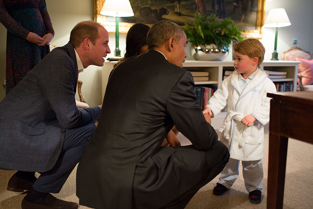 LONDON, ENGLAND - APRIL 22:   In this handout provided by The White House, President Barack Obama, Prince William, Duke of Cambridge and First Lady Michelle Obama talks with Prince George at Kensington Palace on April 22, 2016 in London, England. The President and his wife are currently on a brief visit to the UK where they attended lunch with HM Queen Elizabeth II at Windsor Castle and later dinner with Prince William and his wife Catherine, Duchess of Cambridge at Kensington Palace. Mr Obama visited 10 Downing Street this afternoon and held a joint press conference with British Prime Minister David Cameron where he stated his case for the UK to remain inside the European Union. (Photo by Pete Souza/The White House via Getty Images)