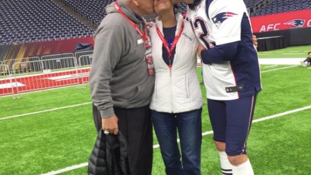 New England Patriots quarterback Tom Brady sits on the turf after