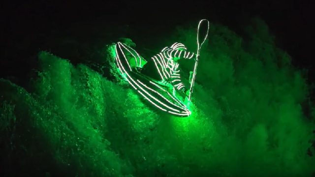 guy kayaks at night in led suit_