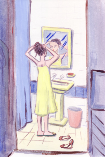 A woman fixing her hair in a bathroom mirror
