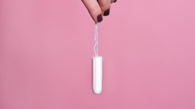 Woman's hand holding a clean cotton tampon