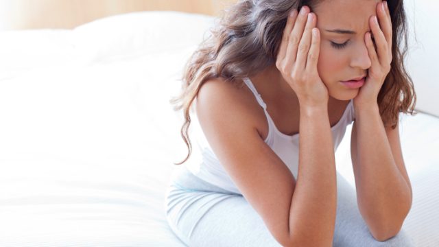 Woman on bed in pain