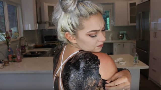 woman applies black head mask on entire body