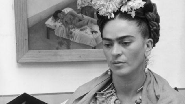 Frida Kahlo in front of one of her pieces of art