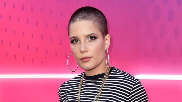 Halsey with a shaved head wearing stripes.