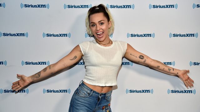 Miley Cyrus raising her arms at Sirius XM
