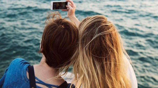 Two friends taking a selfie near the ocean