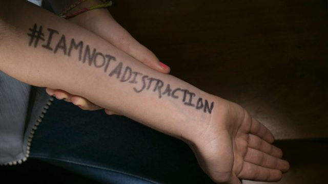 A student wrote #IAmNotADistraction on her arm to protest school dress codes.