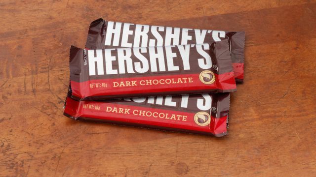 Three bars of Hershey dark chocolate bars on a wooden table