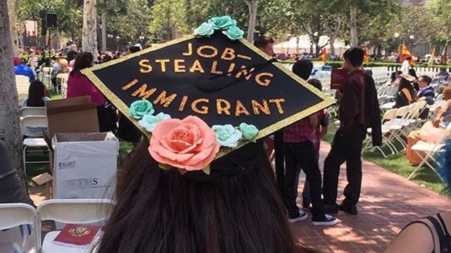 A graduation cap that says "job stealing immigrant" supporting the #ImmiGrad hashtag