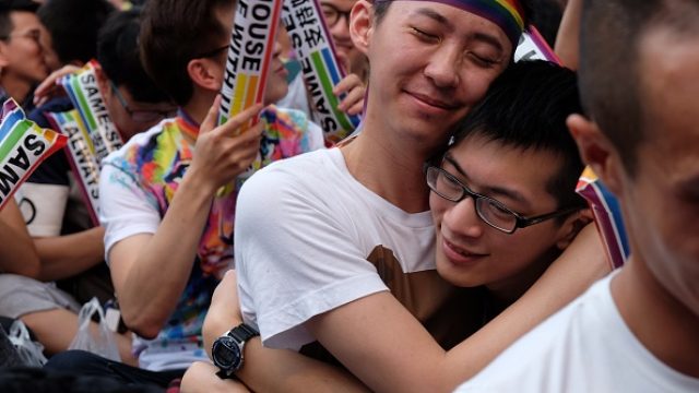 Two gay men hug at an LGBT gathering