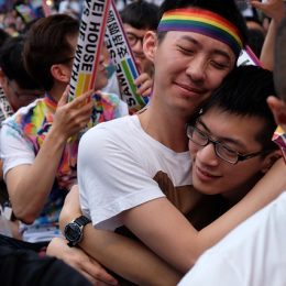Two gay men hug at an LGBT gathering