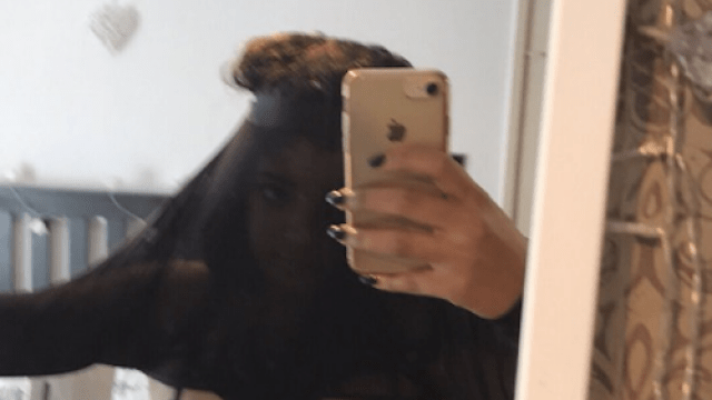 Woman attempting to pull mesh top over her head