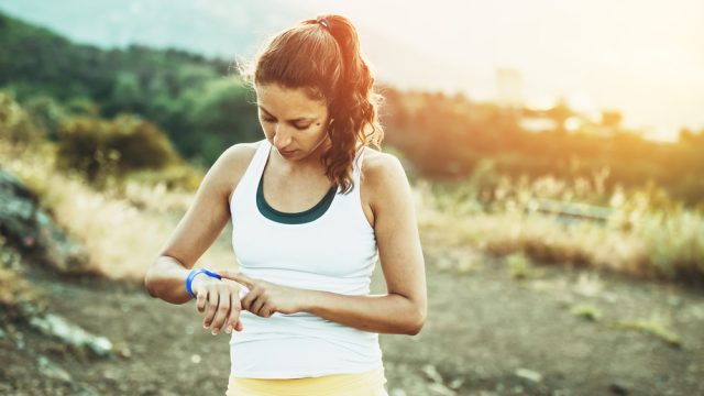 Woman outside looking at her fitness tracker