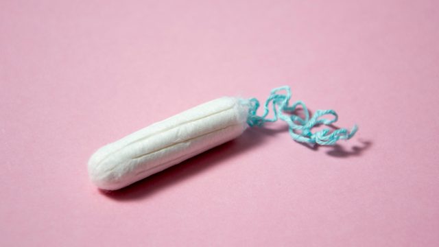 A single tampon on a pink table