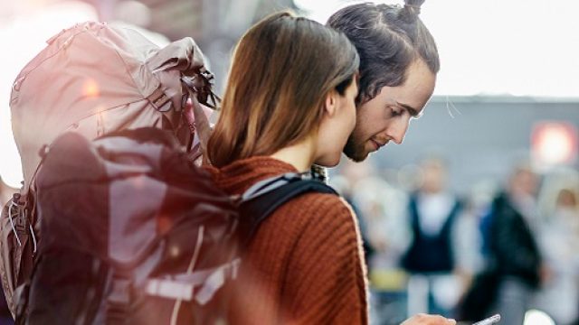 A backpacker couple with smart phone at the airport