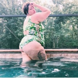 Plus-sized lifeguard Courtney Harrough poses poolside in a green bathing suit