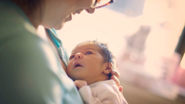 Mom smiling at newborn at hospital