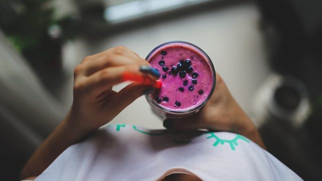 Woman holding blue smoothie