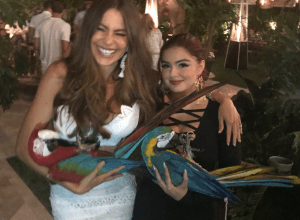 Sofia Vergara and Ariel Winter holding parrots at Memorial Day Party.