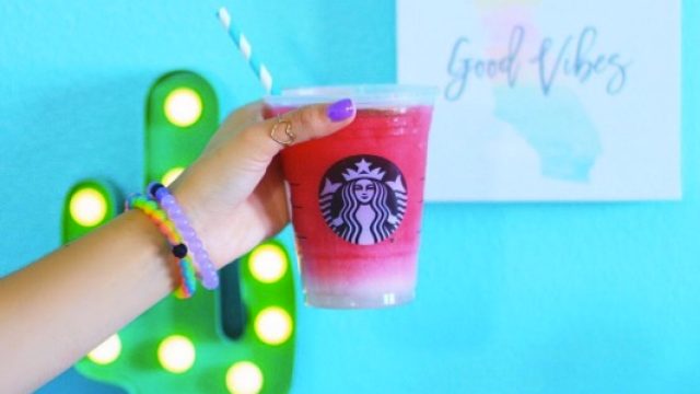 A hand holds up the Starbucks Ombre Pink Drink