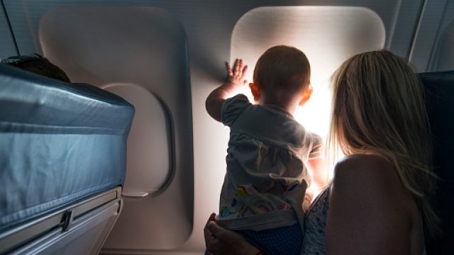 Baby looking out airplane window
