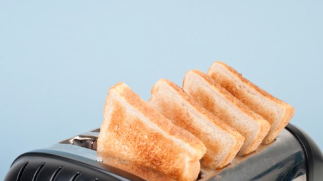 Four slices of white toast in four-slot toaster, close-up