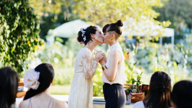 Young lesbian couple kissing during their wedding ceremony