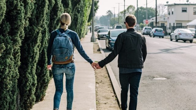 Couple holding hands while walking down the street