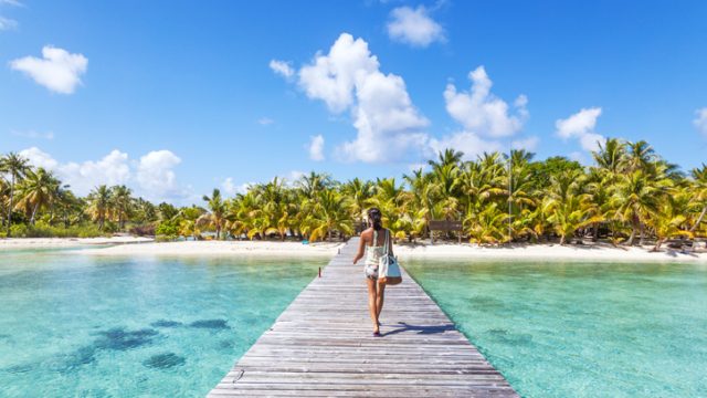 Tourist walking on jetty, Tikehau atoll, Tuamotu Archipelago, French Polynesia, Oceania