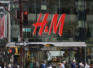 Shoppers walk past the entrance to the H&M clothing store on Fifth Avenue in Midtown Manhattan in New York City, New York.