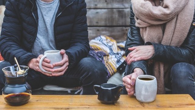 Two people talking and drinking coffee