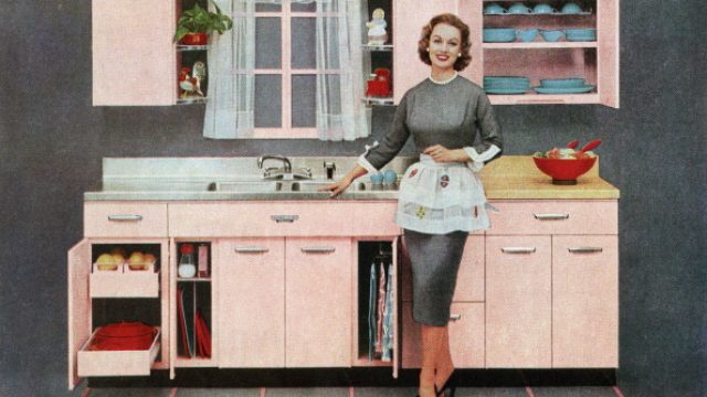 A housewife stands in a pink kitchen in a vintage illustration from the 1950s