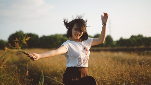 girl plays in field in summer