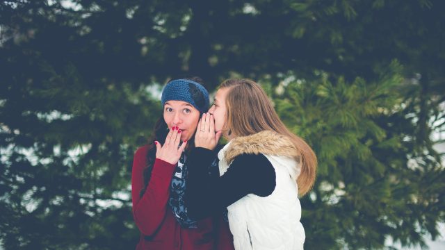 girl whispers to a friend