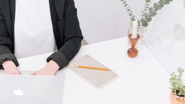 woman at a desk typing on laptop